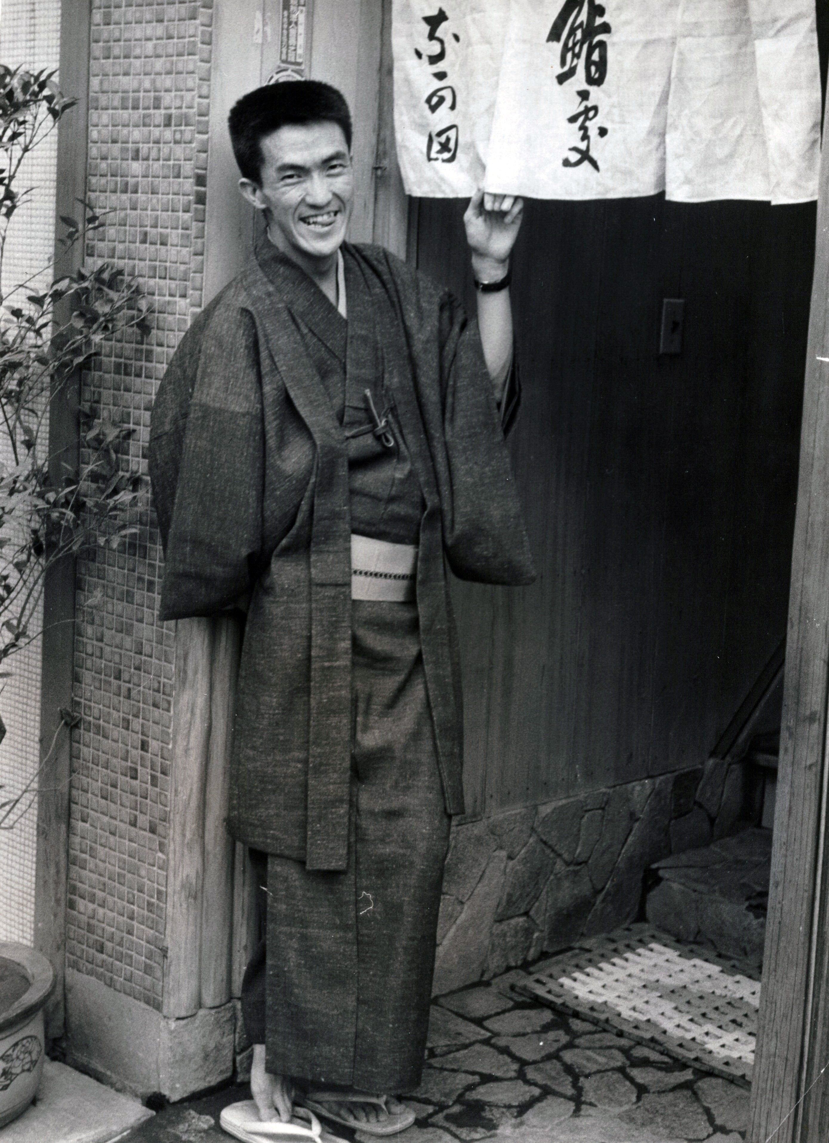 のれんの前に立つ永六輔